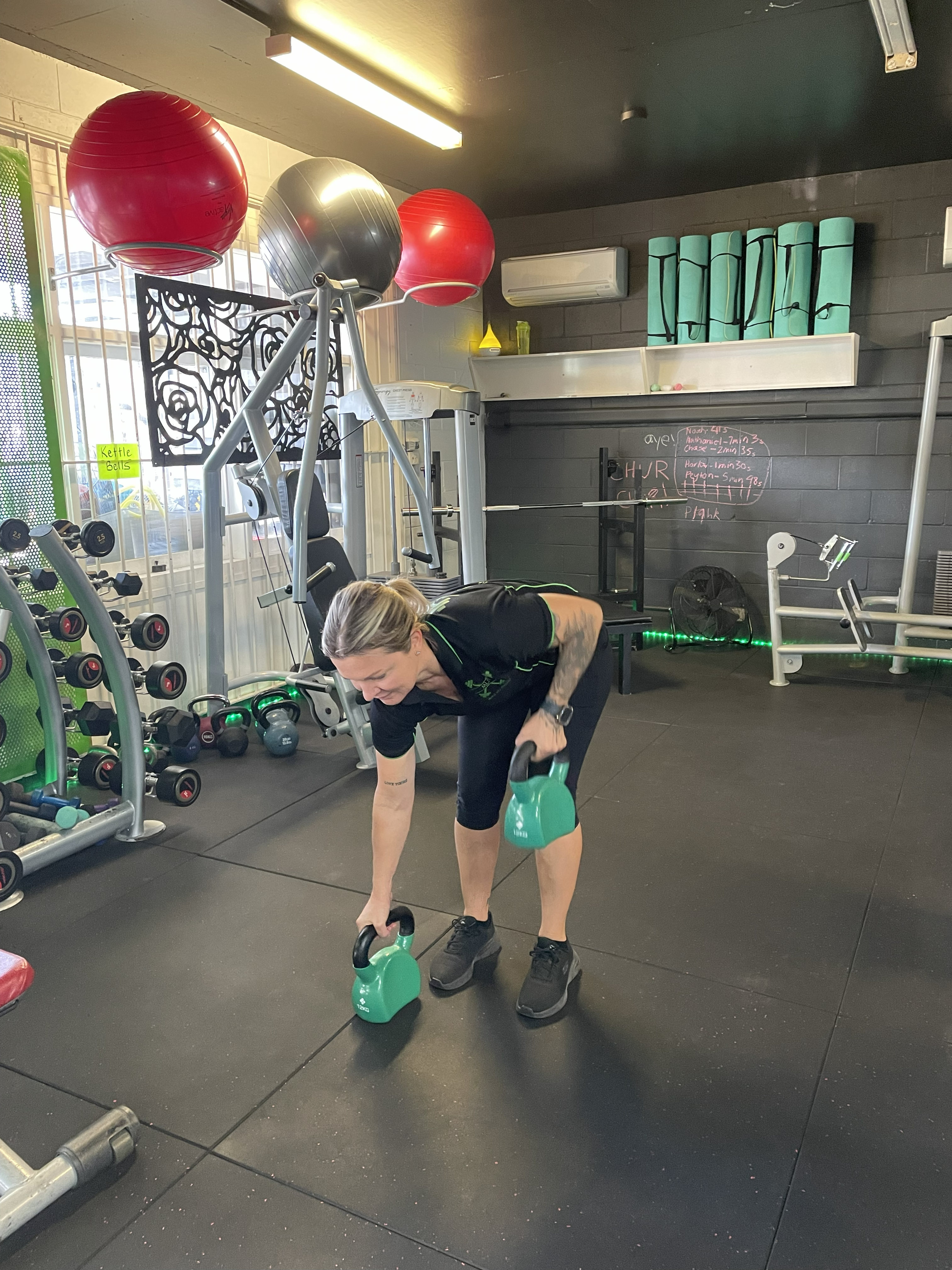 Woman performing kettlebell bent over row at gym